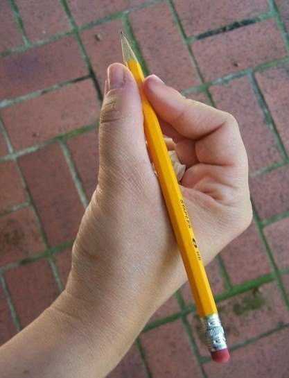 Вместе с большим пальцем, указательный удерживает карандаш